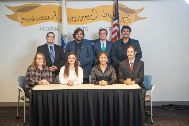 SGA Executive Council featuring 8 students with Student Government banner behind them.