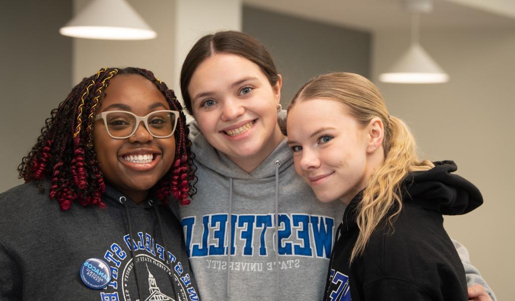 Three students smiling wearing Westfield State sweatshirts.